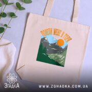 Шопер поведи мене в гори подарунок бежевий, на фоні рослин, бренд Згадка.