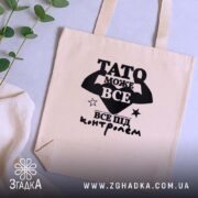 Шопер Тато може все, бежевий, на столі, з рослиною, бренд Згадка.