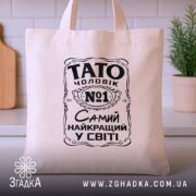 Шопер Тато найкращий чоловік, бежевий, ракурс спереду, кухня на фоні, бренд Згадка.