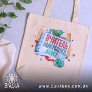 Шопер вчитель найкращого класу, бежевий, на столі з рослинами, бренд Згадка.