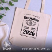 Шопер випускник 2026 подарунок на випускний, бежевий, на столі з рослинами, принт.