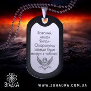 Жетон янгол охоронець чорного кольору з дзеркальною поверхнею, зображення з ракурсу спереду на фоні з червоними та жовтими відтінками, видно кулю на задньому плані.