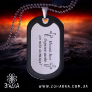 Жетон оберіг для військового, чорний з матовою поверхнею, з дзеркальним сріблястим центром, зображений під кутом на фоні червоного та чорного вогню, видно кулю на задньому плані.