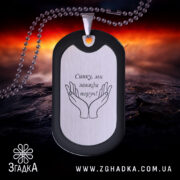 Жетон подарунок для сина, чорний з матовою поверхнею, зображення рук на сріблястому фоні, ракурс з близької відстані, фон з червоними та чорними відтінками, видно кулю на задньому плані.