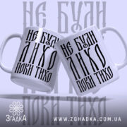 Чашка не буди лихо поки тихо, дві чашки з написом на фоні,.