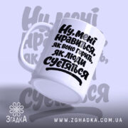 Чашка нравиться як воно горить, ракурс знизу, біла з чорним текстом, бренд.