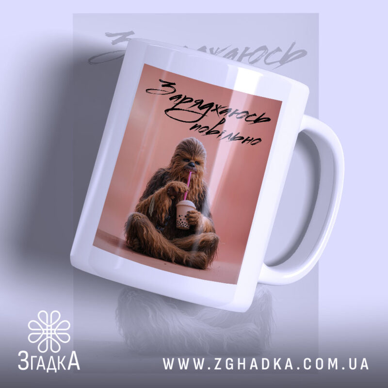 Чашка заряджаюсь повільно з принтом, на фоні м'який колір, бренд Згадка.