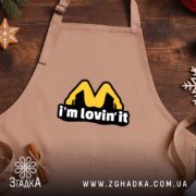 Фартух I’m lovin’ it, бежевий фон, дерев’яний стіл, бренд Згадка.