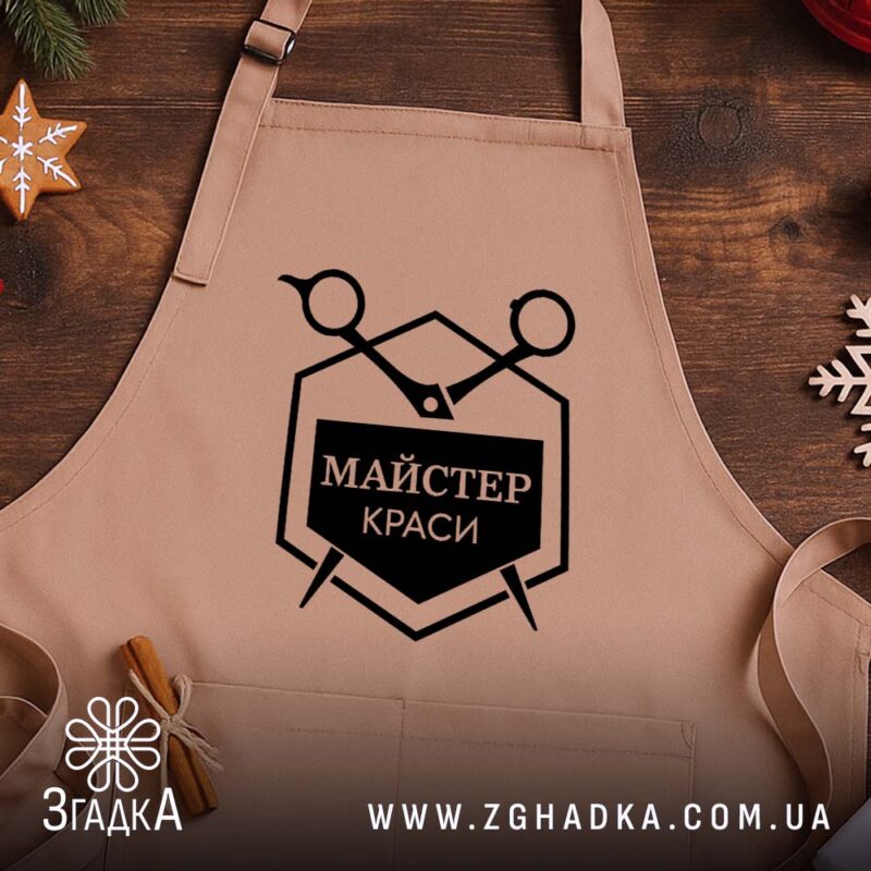 Фартух майстер краси, бежевий, на дерев'яному фоні, з логотипом Згадка.