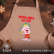 Фартух перша дівка на селі, бежевий, на дерев'яному фоні, бренд Згадка.