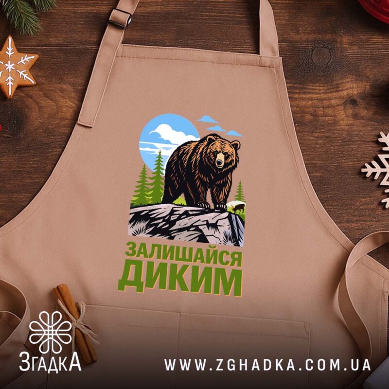 Фартух залишайся диким ведмежий принт, бежевий фон, дерев'яний стіл, бренд Згадка.