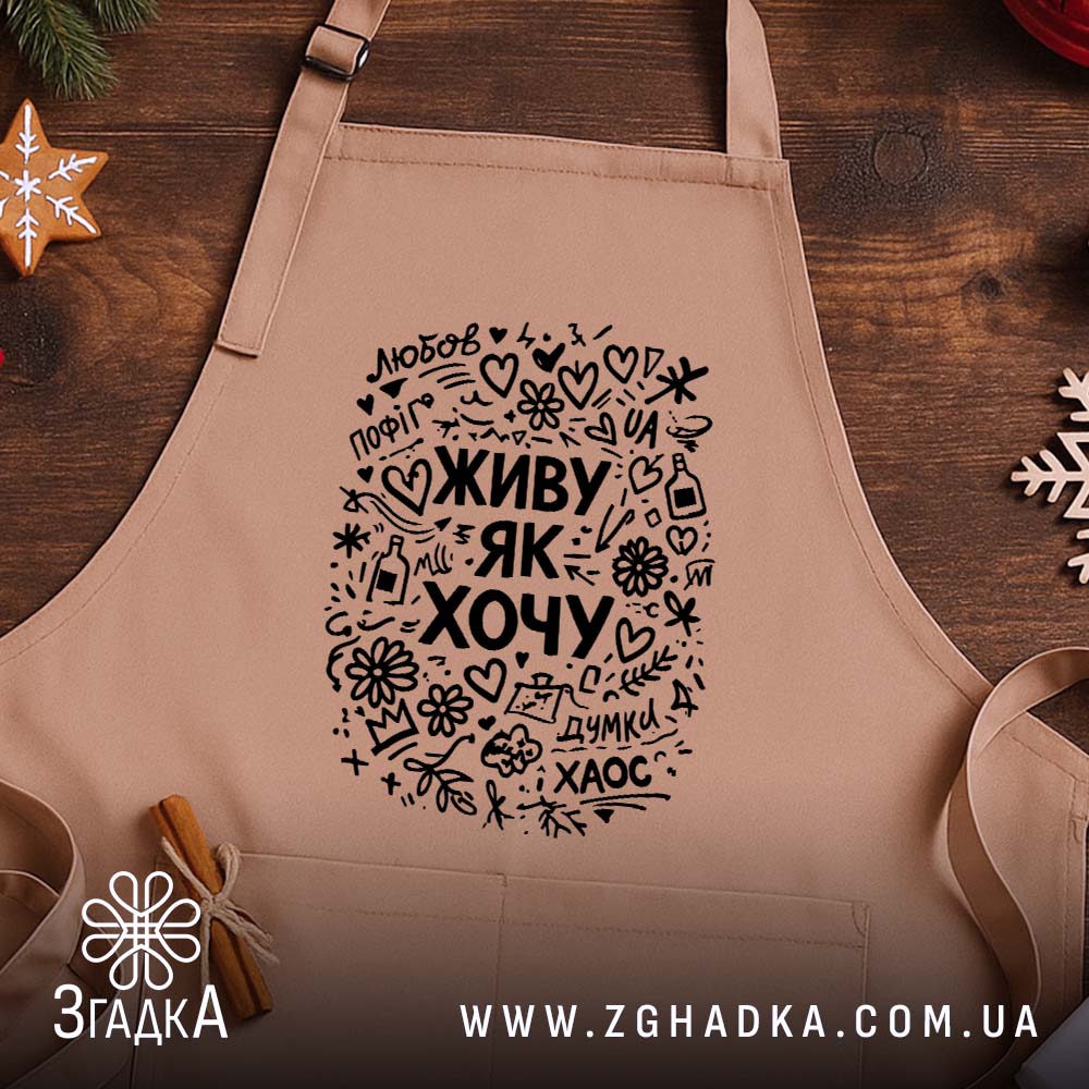 Фартух живу як хочу, бежевий, на дерев'яному фоні, бренд Згадка.