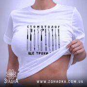 Футболка стоматолог, біла, на моделі, з піднятим краєм, принт з інструментами, бренд.