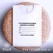 Футболка у разі зникнення, складена на кошику, біла, бренд Згадка.