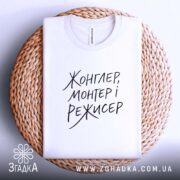 Футболка жонглер монтер і режисер, складена на кошику, біла, текст на видимій.