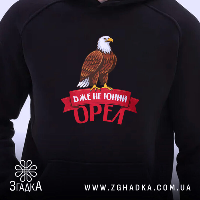 Худі вже не юний орел, близький план, чорний фон, яскравий принт, бренд.