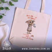 Шопер Доббі чекає шкарпетку, бежевий, на фоні рослин, бренд Згадка.