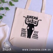 Шопер дикий захід на столі, бежевий з чорним принтом, фон з рослинами,. ракурс 5