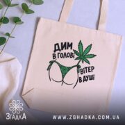 Шопер дим в голові на столі, бежевий фон, принт з листям, бренд.