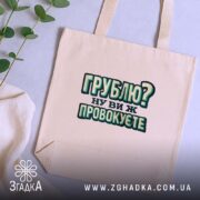Шопер грублю ну ви ж провокуєте, бежевий, на столі з рослинами, акуратний.
