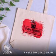 Шопер я настоюю на натуральному, бежевий, на фоні рослин, з червоним принтом,.