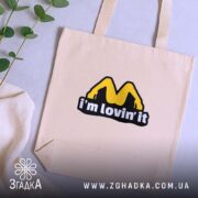 Шопер I’m lovin’ it бежевий, з рослинами, на фоні, бренд Згадка.