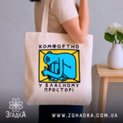 Шопер комфортно у власному просторі, бежевий, у руках, з яскравим принтом, бренд.