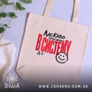 Шопер ласкаво просимо в систему, бежевий, на фоні рослин, з принтом, бренд.