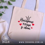 Шопер найкраща теща, бежевий, на столі з рослинами, простий дизайн, бренд Згадка.