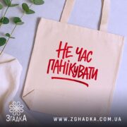 Шопер не час панікувати, бежевий, з червоним принтом, на фоні рослин, бренд.