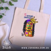 Шопер шукаю принца, бежевий на столі, яскравий принт, бренд Згадка.