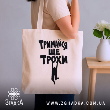 Шопер тримайся ще трохи, бежевий, на плечі, стильний фон, бренд Згадка.