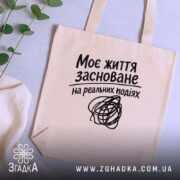Шопер життя на реальних подіях, бежевий, на столі з рослинами, бренд Згадка.