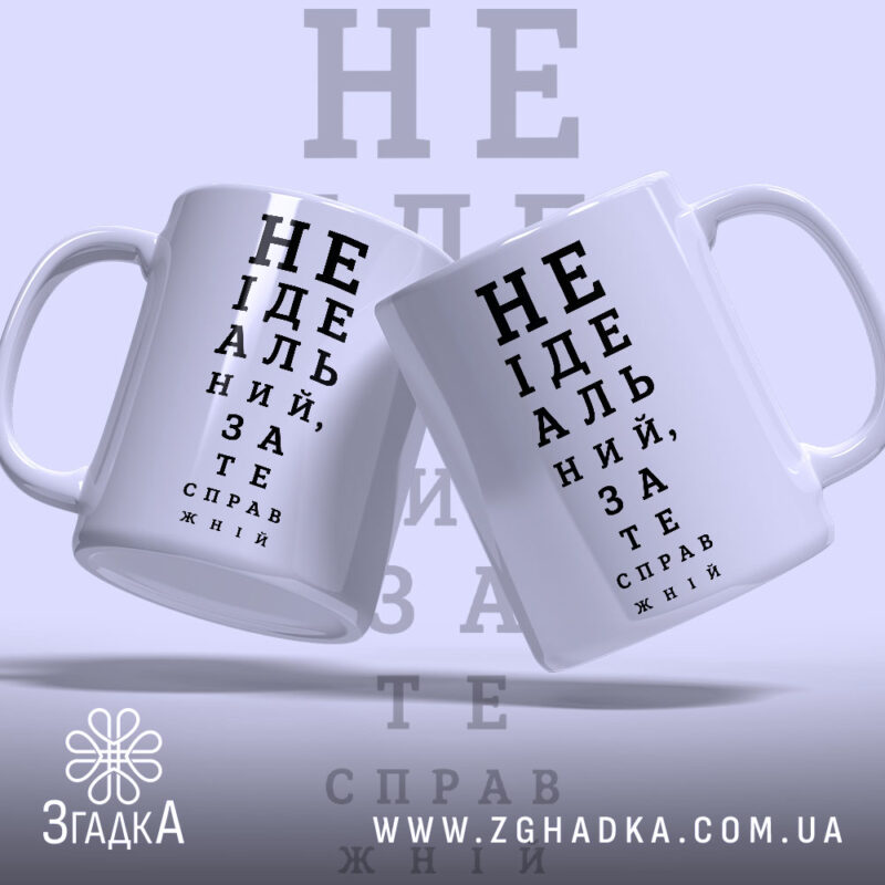 Чашка не ідеальний зате справжній, дві чашки з написом на фоні, бренд.