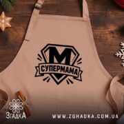 Фартух cупермама найкраща мама Фартух супермама найкраща мама, бежевий, на дерев'яному фоні,.