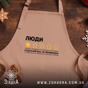 Фартух люди не рекомендую, бежевий, на дерев'яному фоні, бренд Згадка.