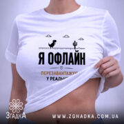 Футболка перезавантажуюсь у реальності, біла, на моделі, з піднятим краєм, принт на.