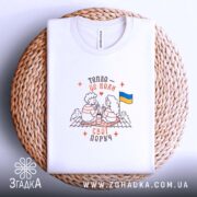 Футболка свої поруч, на столі, біла з принтом, бренд Згадка.