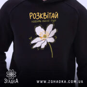 Худі розквітай навіть після бурі, близький план, чорний фон, квітка на грудях,.