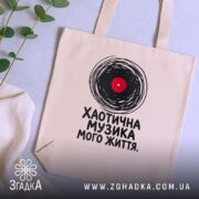 Шопер хаотична музика, бежевий, на столі, зелений фон, бренд Згадка.