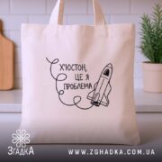 Шопер Х’юстон це я проблема, бежевий, фронтальний ракурс, з принтом ракети, бренд.