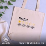 Шопер люди не рекомендую, бежевий на столі з рослинами, бренд Згадка.