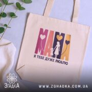 Шопер Мама я тебе дуже люблю, бежевий, на столі, бренд Згадка.
