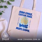 Шопер море кличе, бежевий на столі з рослинами, бренд Згадка.