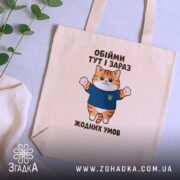 Шопер обійми тут і зараз, бежевий, на столі, котик у синій футболці,.