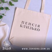 Шопер пенсія близько бежевий на столі з рослинами Згадка.