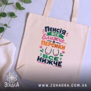 Шопер пенсія все ближче на столі, бежевий, з рослинами, яскравий принт, бренд.