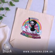 Шопер ще один дебіл на столі, бежевий, яскравий принт, зелена рослина, бренд.