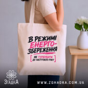 Шопер в режимі енергозбереження, бежевий, на плечі, текст на передній частині, бренд.