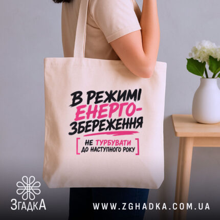 Шопер в режимі енергозбереження, бежевий, на плечі, текст на передній частині, бренд.